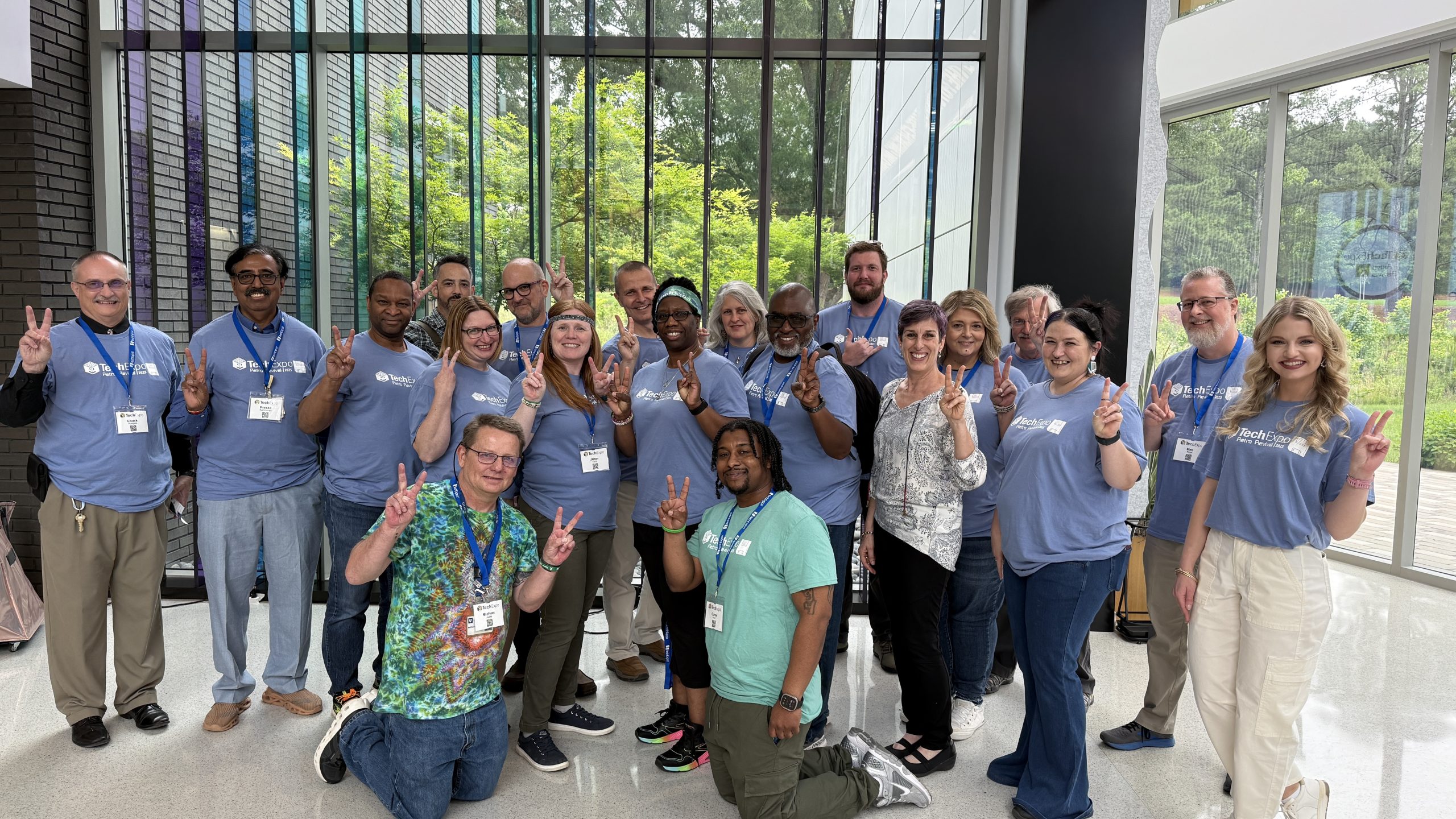 The TechExpo 2025 committee poses together at Apella while making the "peace" sign gesture to celebrate the event of another successful TechExpo event.